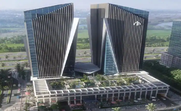 Two glass-clad commercial towers rising from a landscaped podium